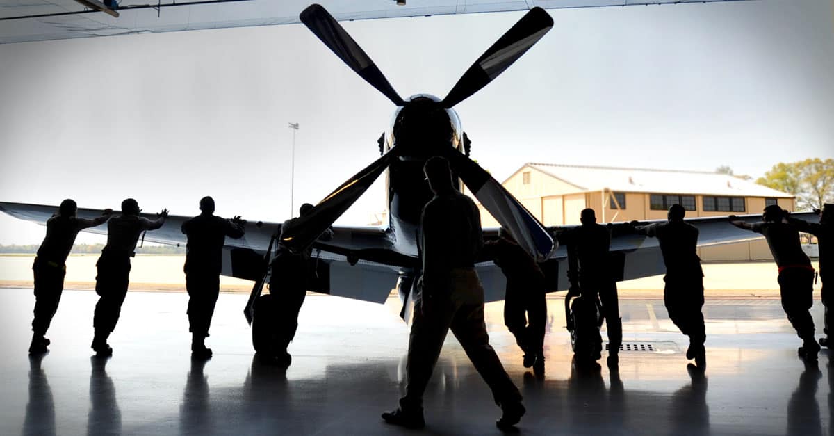 P-51-U.S. Air Force airmen help push a P-51 Mustang out of a hanger before takeoff, Shaw Air Force Base